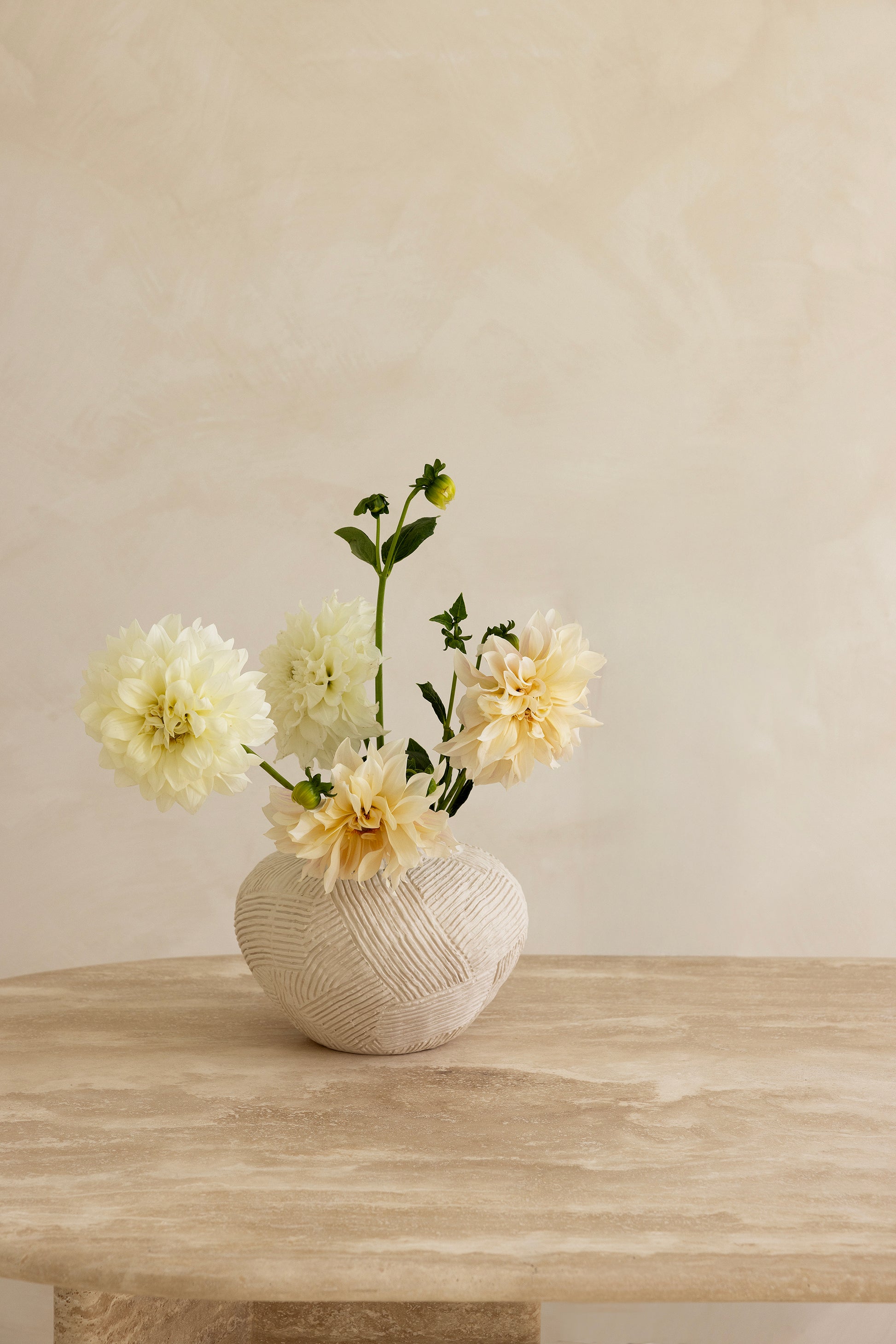 A rectangular dining table with curved edges, made of light-colored wood, displayed against a neutral background.