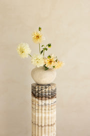 A beige travertine decorative tray with a wave pattern, displayed on a plain background.