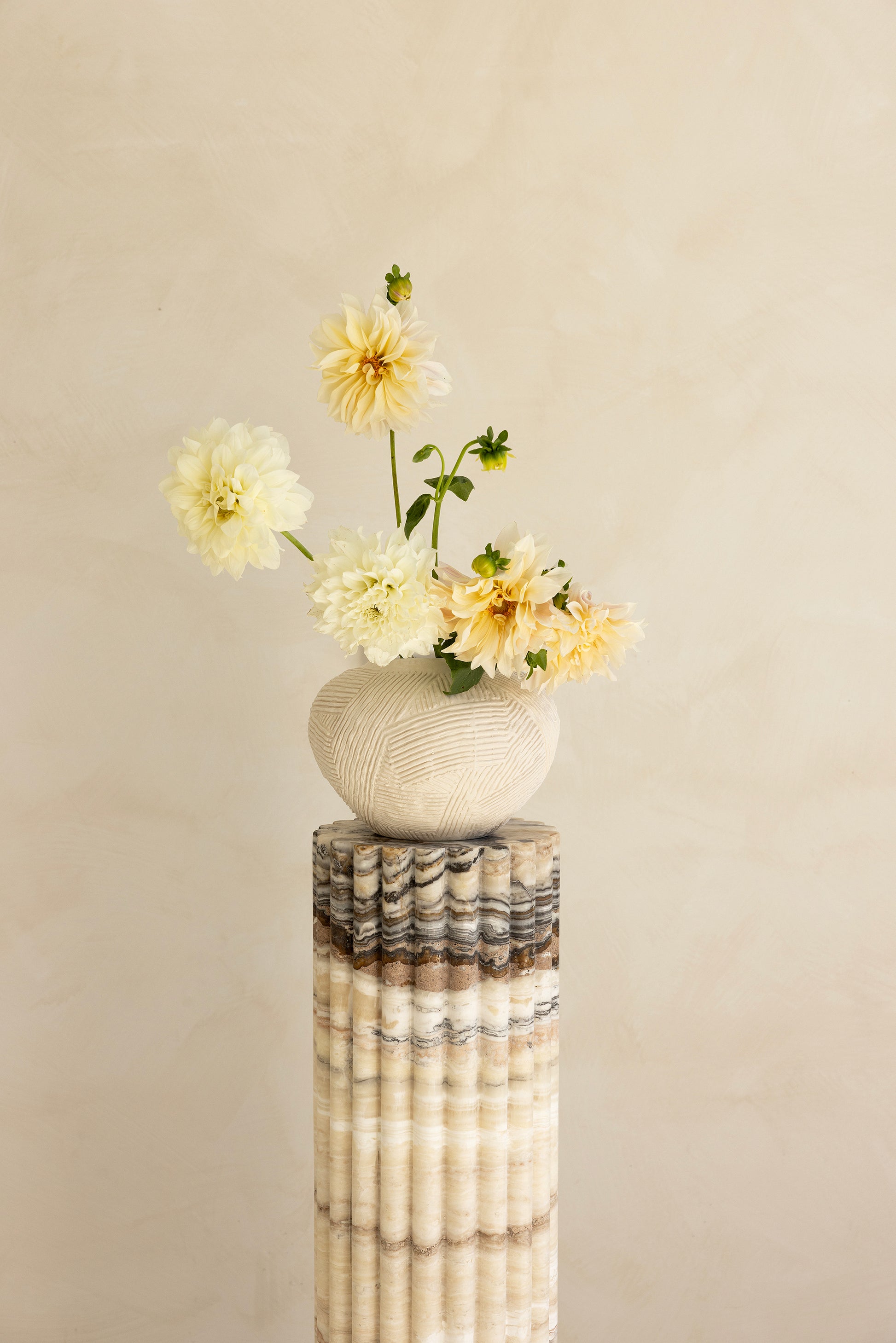 A beige travertine decorative tray with a wave pattern, displayed on a plain background.