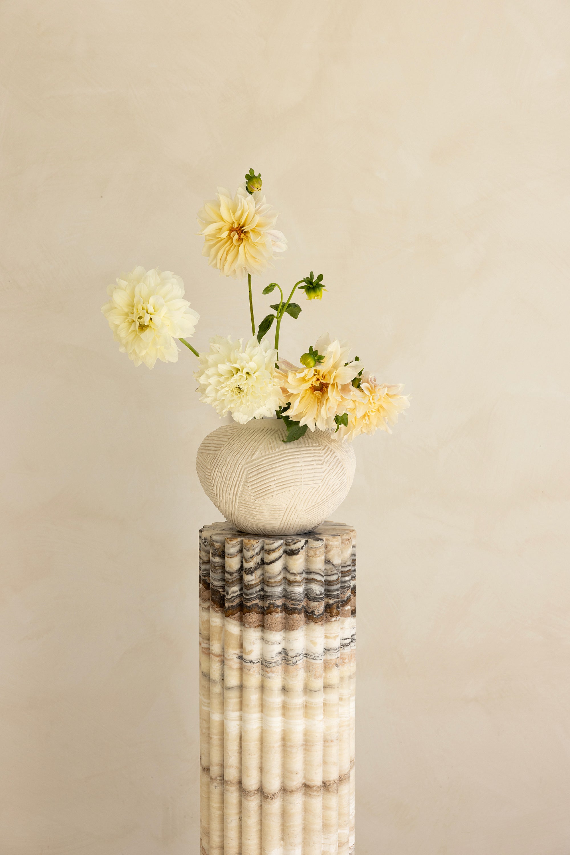 A beige travertine decorative tray with a wave pattern, displayed on a plain background.