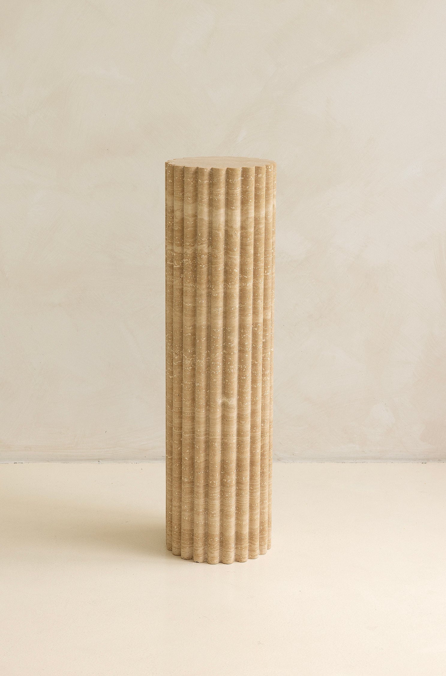 A beige travertine decorative tray with a wave pattern, displayed on a plain background.