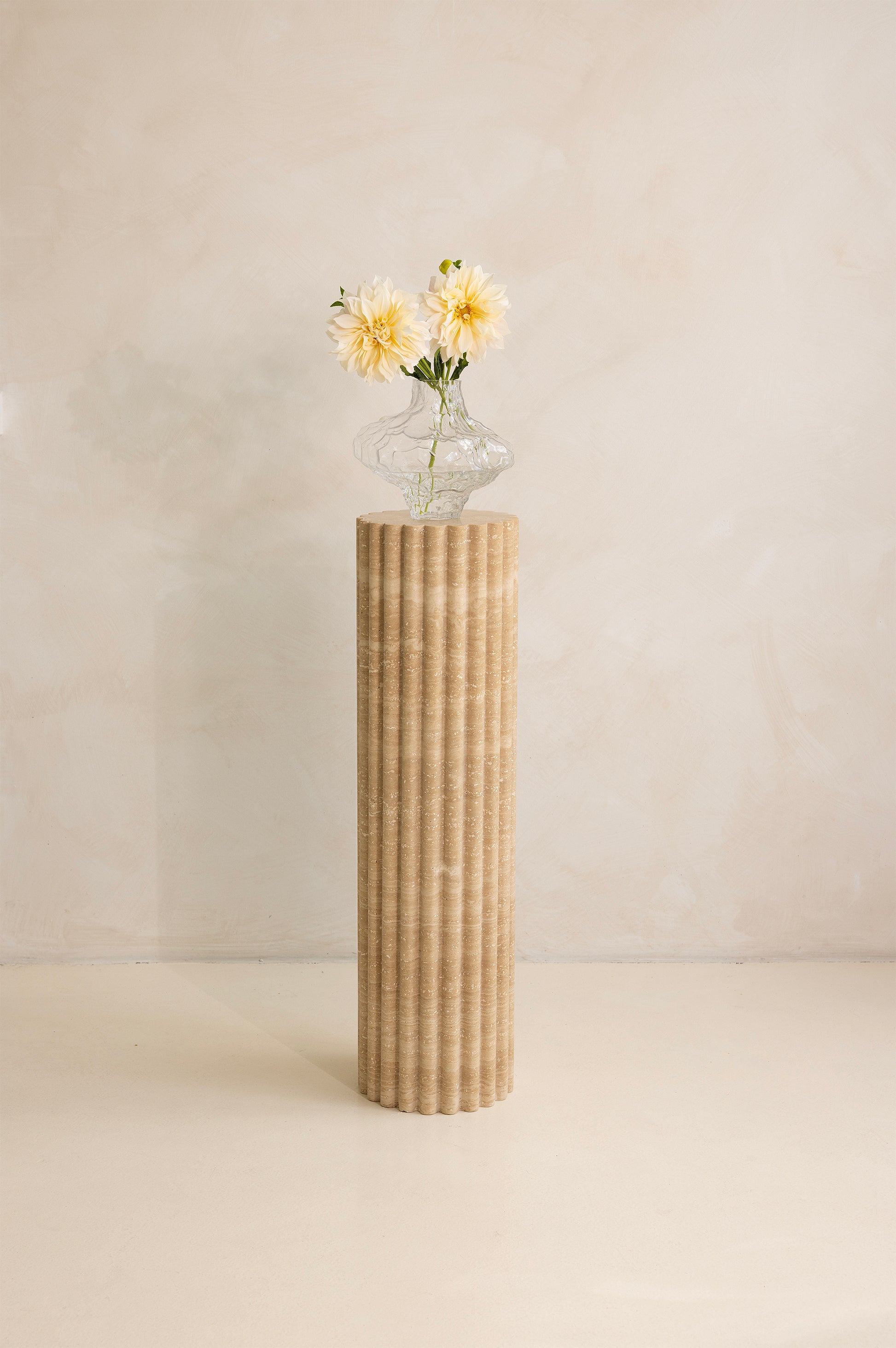 A beige travertine decorative tray with a wave pattern, displayed on a plain background.
