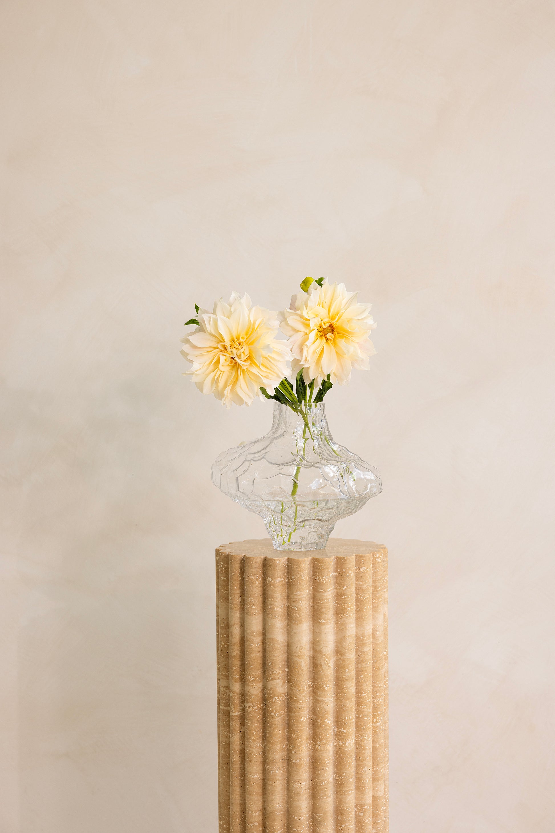 A beige travertine decorative tray with a wave pattern, displayed on a plain background.